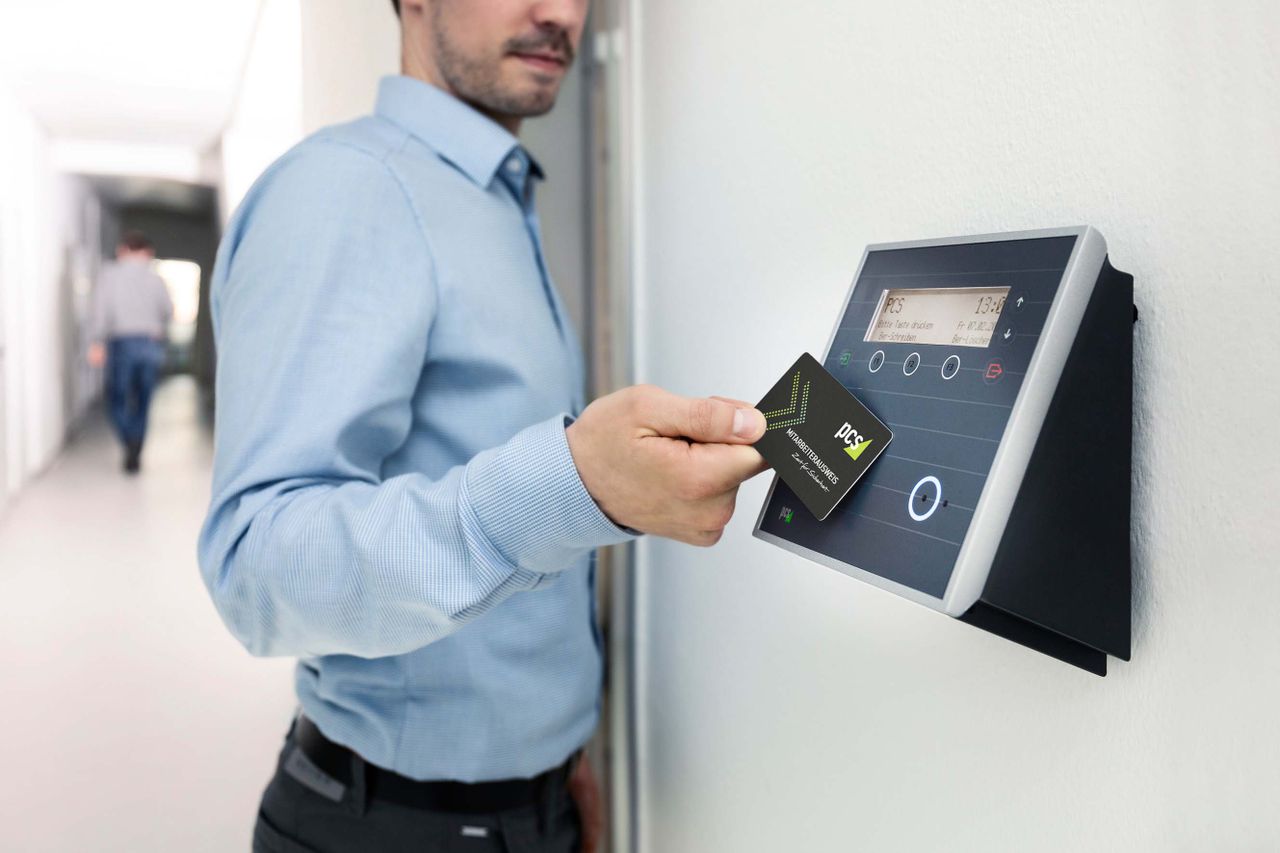Service Businessman uses RFID card reader for secure office access, enhancing workplace security.