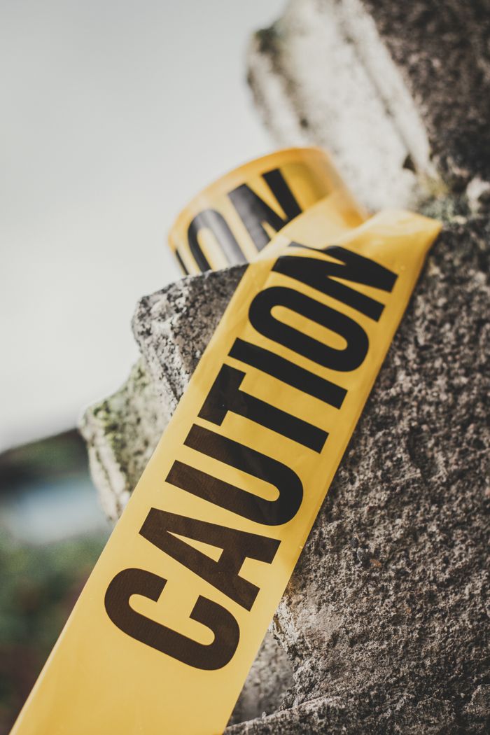Service Limiting bright tape with inscription caution on cement surface to show danger zone
