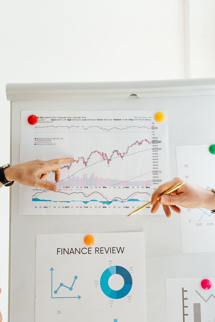 Service Hands pointing to financial charts during an office presentation.